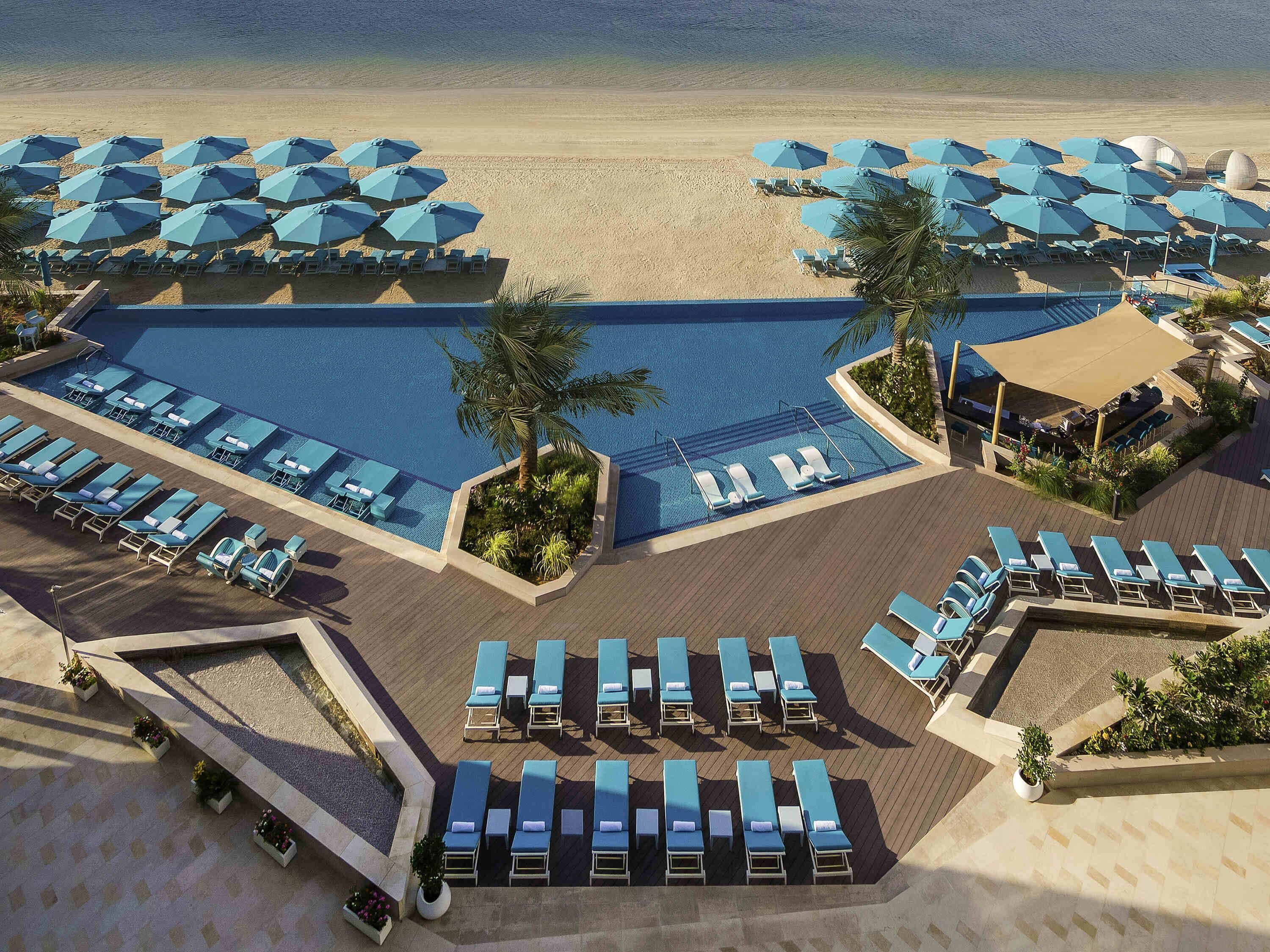 Een buitenzwembad, parasols voor strand/zwembad