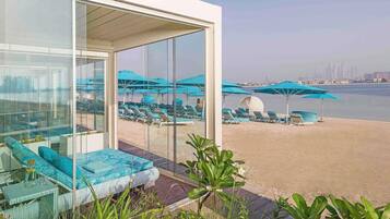 Een buitenzwembad, parasols voor strand/zwembad