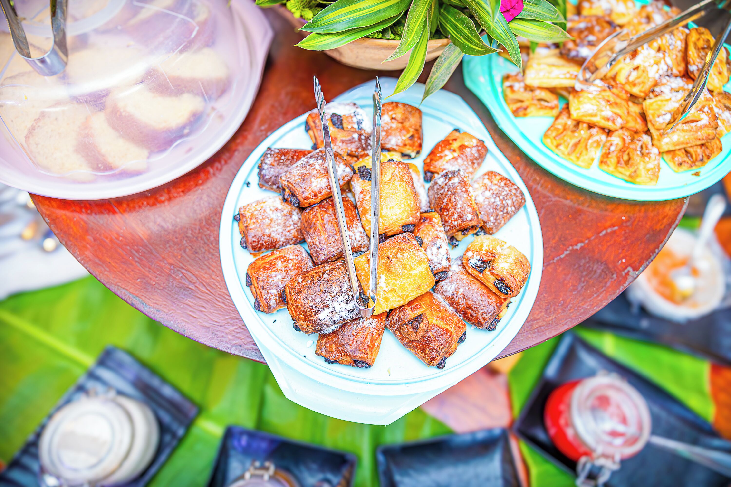 A variety of food items on a table, including pastries and a drink in a plastic cup.