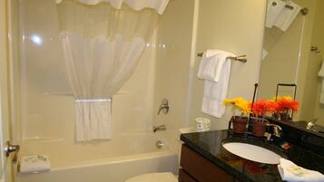 A bathroom with a bathtub, toilet, sink, and a mirror.