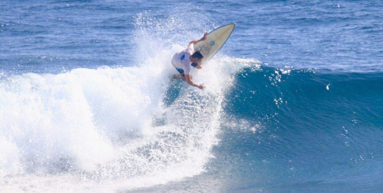 A person surfing a wave in the ocean.
