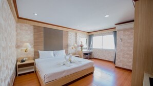Une chambre d’hôtel moderne, dotée d’un grand lit, d’un bureau et d’une armoire.
