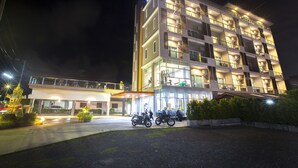 A multi-story hotel with a well-lit entrance and several balconies. - The Elysium Residence (Chalong)