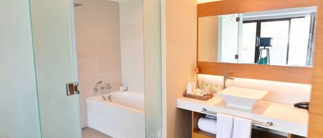 A modern bathroom with a glass-enclosed shower, a freestanding bathtub, and a vanity with a large mirror.