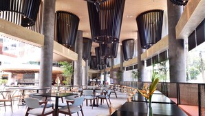 A spacious indoor dining area with multiple tables and chairs, large pillars, and hanging light fixtures. - Hue Hotels and Resorts Boracay Managed by HII (Boracay Island)