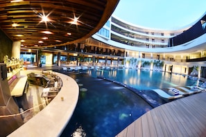 Piscine couverte, piscine extérieure, parasols de plage, chaises longues