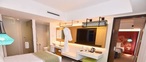 Habitación de hotel con dos camas, un baño, un televisor y una puerta roja.