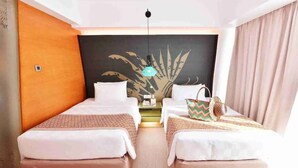 A hotel room with two beds, a large wall mural, a hanging light fixture, and a small table with a decorative item. - Hue Hotels and Resorts Boracay Managed by HII (Boracay Island)