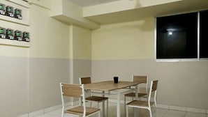 Una habitación con una mesa de comedor y sillas, un ventilador de techo, una ventana y una cámara de seguridad instalada en la pared.