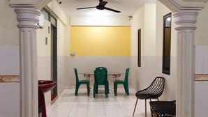 Un comedor con una mesa, sillas, un ventilador de techo y una pared amarilla.