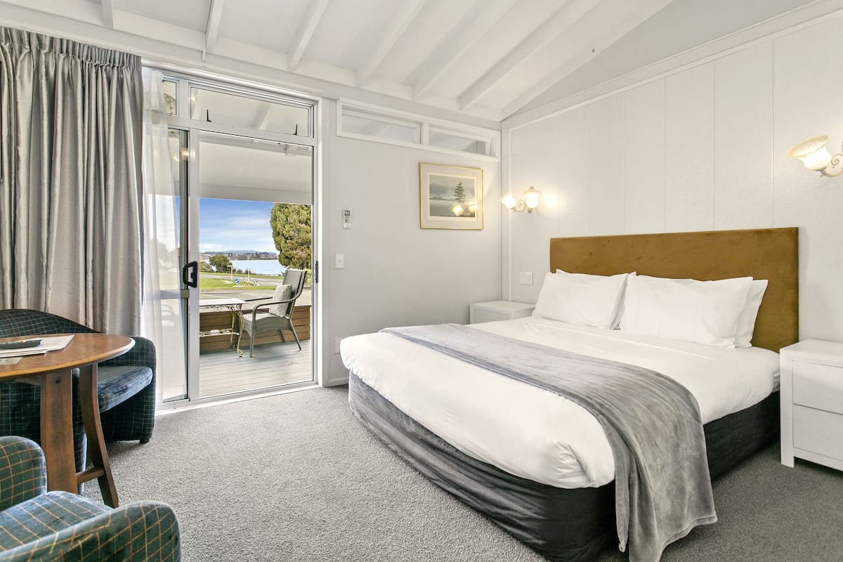 Une chambre d’hôtel avec un lit, un bureau et une vue sur l’extérieur.