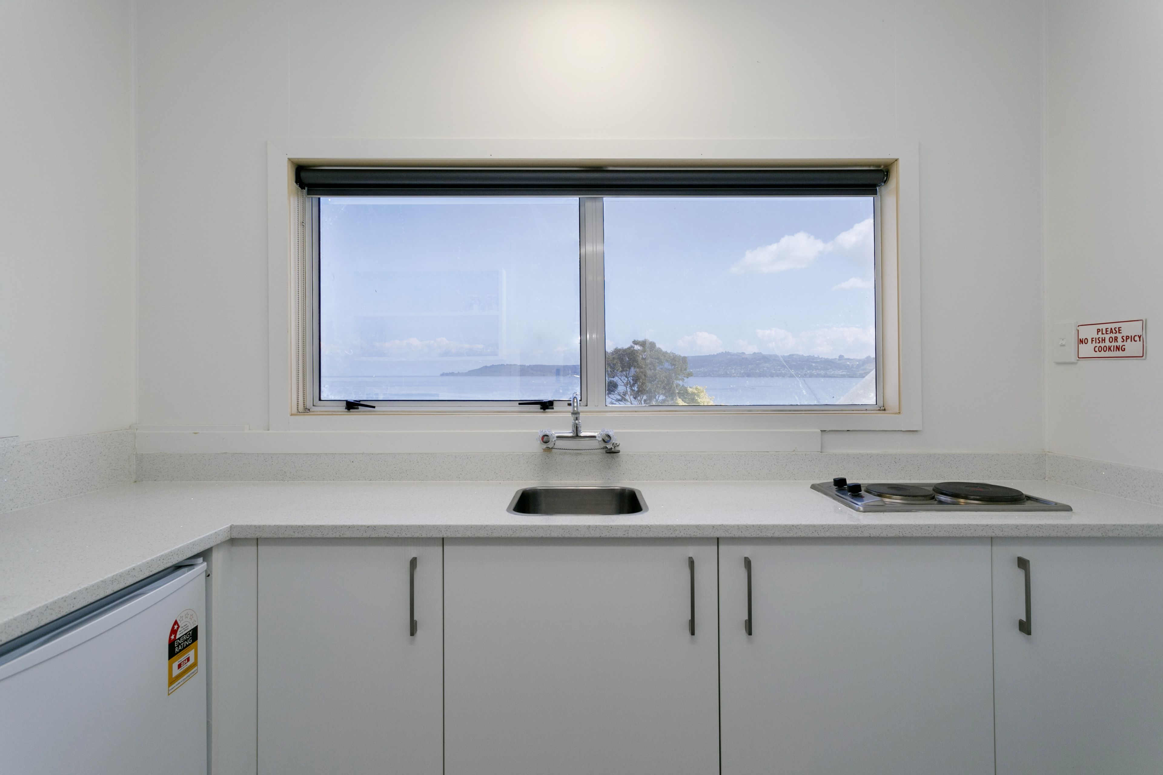 Una cocina con ventana, pileta y estufa.