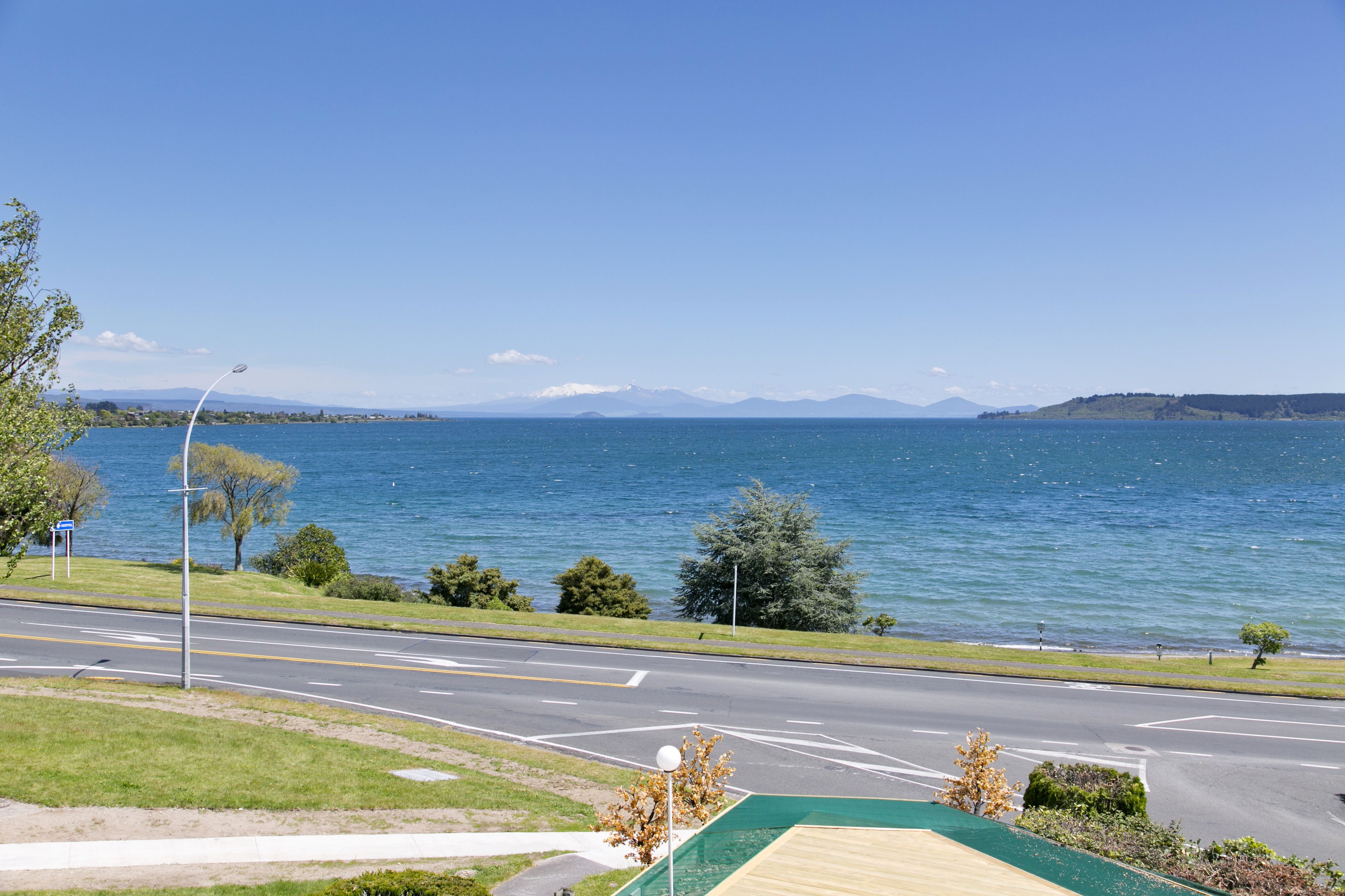 A road leading to a body of water with a clear sky.