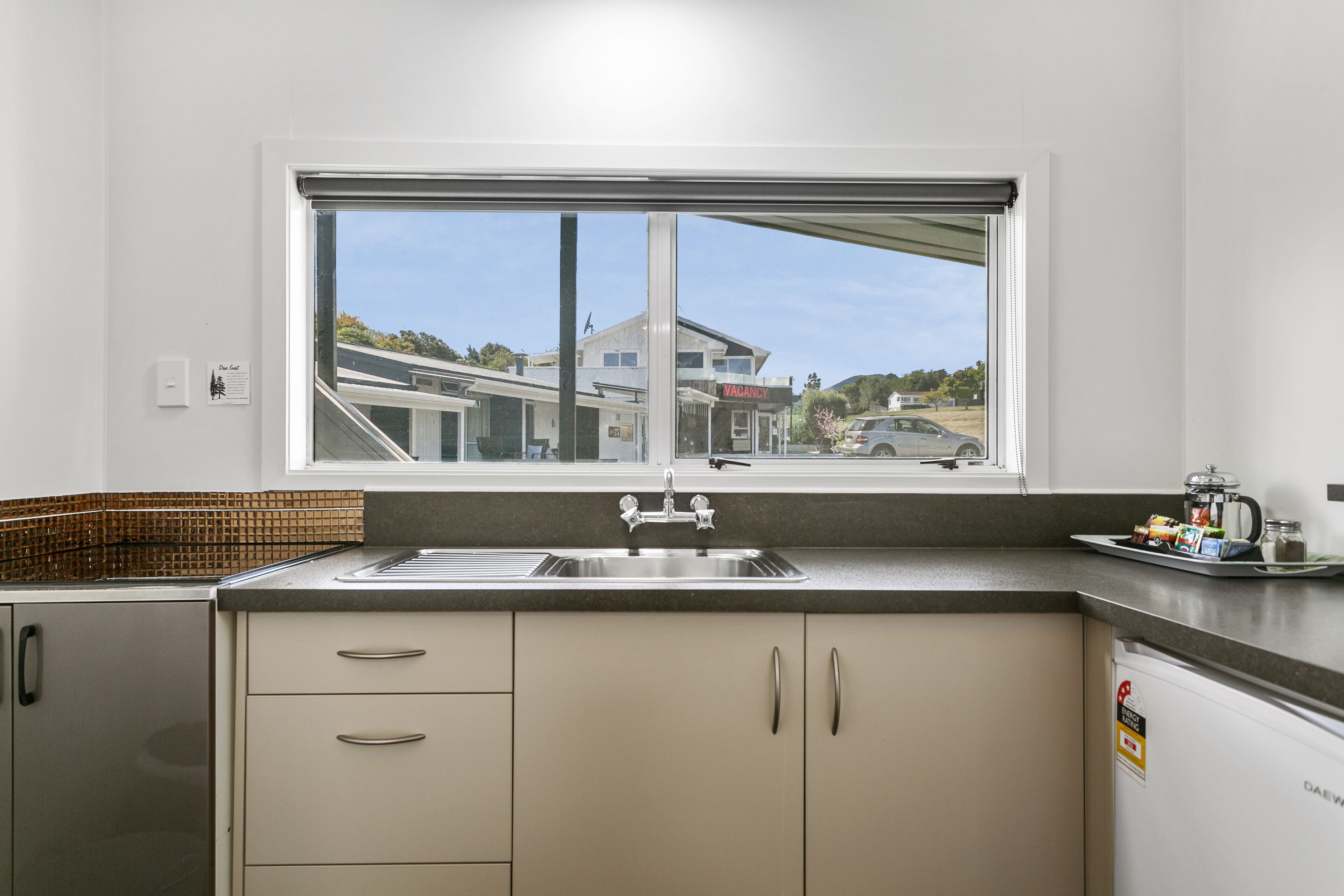 A kitchen with a window, a sink, and cabinets.