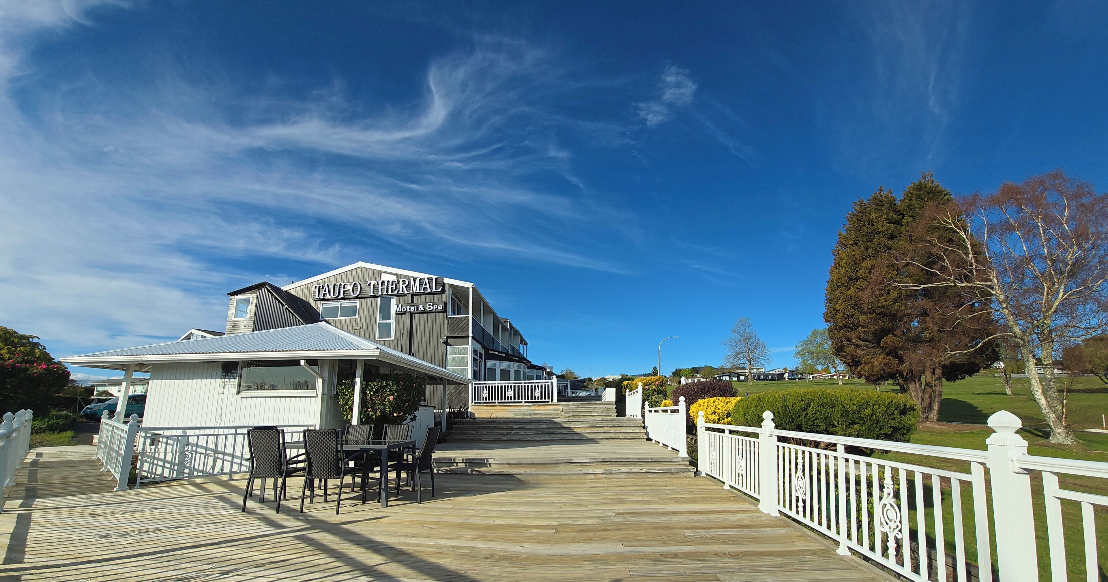 Um hotel com uma passarela que leva a um edifício com a inscrição "TAUPO THERMAL Motel & Spa".
