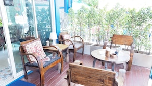 Un área de estar al aire libre con muebles de madera y plantas en macetas.