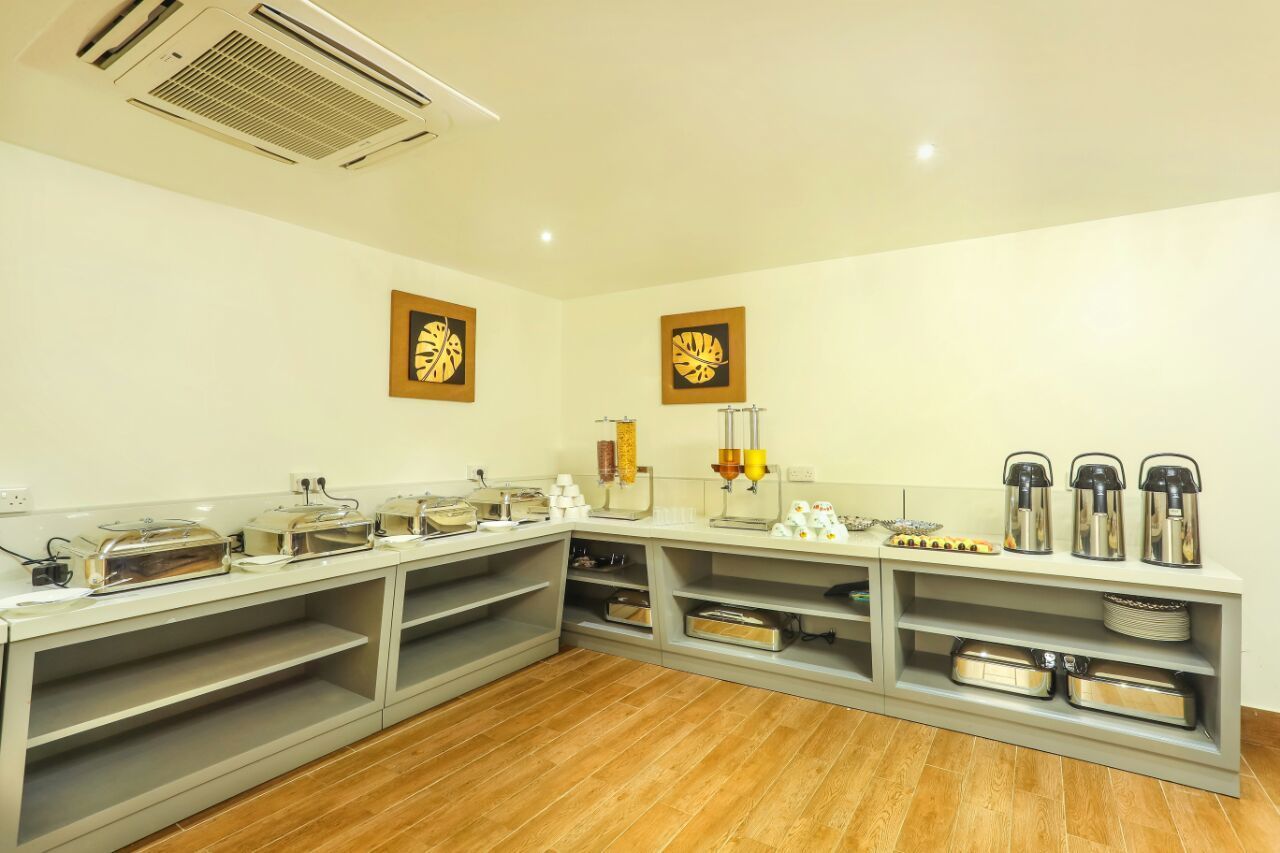A buffet setup with various food containers and serving equipment.