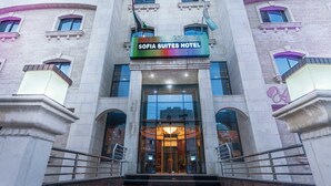 The entrance of Sofia Suites Hotel with a prominent sign, a grand entrance, and a staircase leading up to the doors. - Sofia Suites Hotel (Amman)