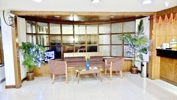 Un vestíbulo con un conjunto de sofás, una mesa de centro y plantas en macetas.