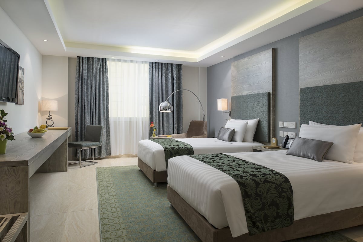Una habitación de hotel moderna con dos camas, un escritorio y una silla.