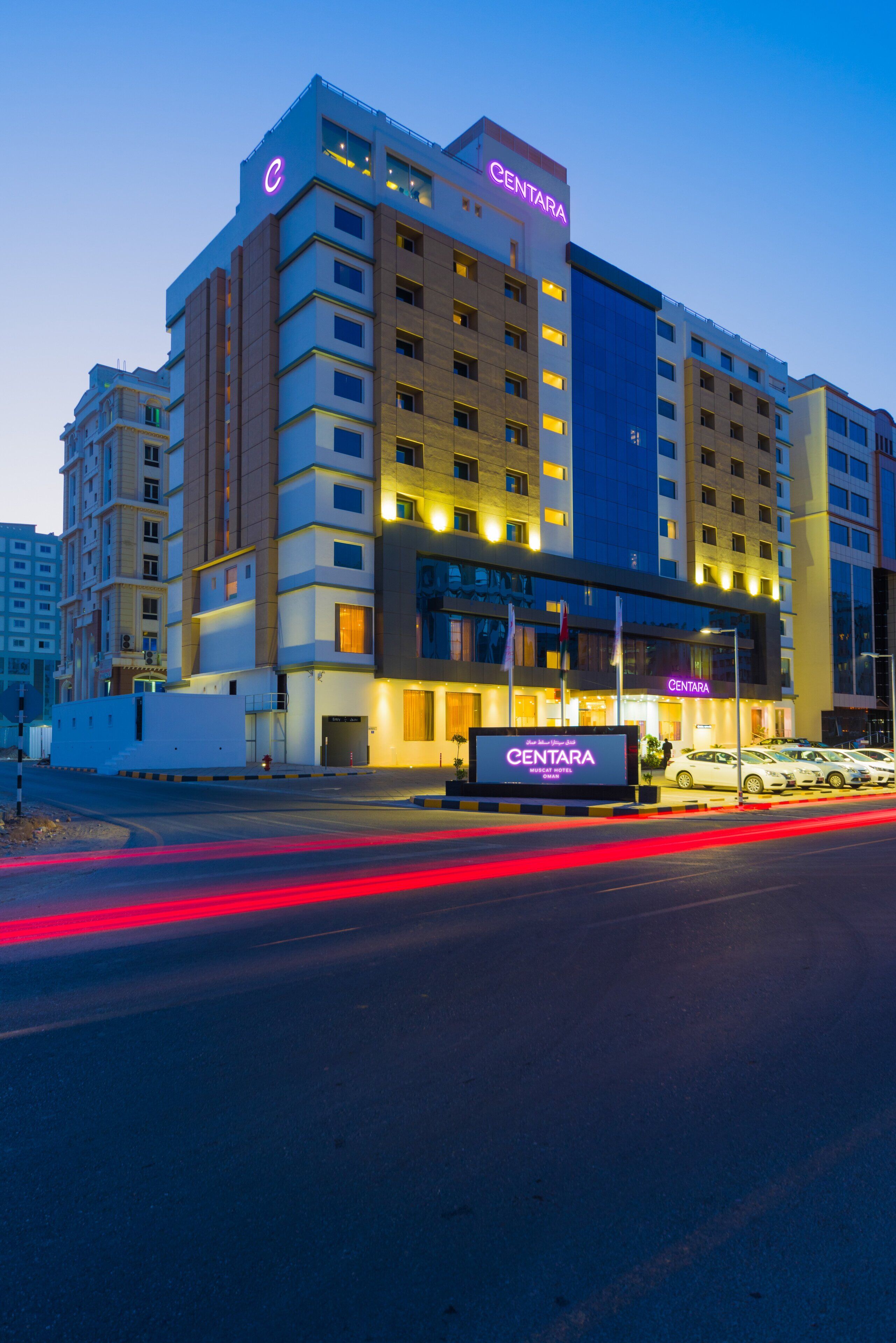 A multi-story hotel with a prominent 'CENTARA' sign, featuring a modern architectural design with multiple balconies and a well-lit facade.