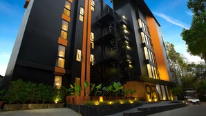 A modern building with a black and orange facade, multiple windows, and a central staircase. - 9.5 Hotel (Chiang Mai)