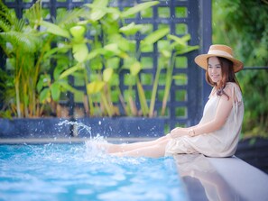 Una piscina al aire libre, sombrillas, sillones reclinables de piscina