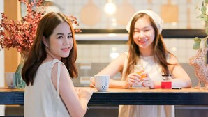 Two individuals seated at a bar with a tiled backsplash and hanging light fixtures. - 9.5 Hotel (Chiang Mai)