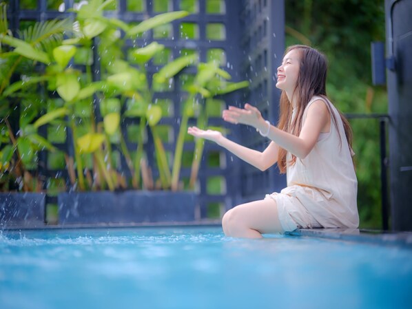 Alberca al aire libre, sombrillas en la alberca y camastros