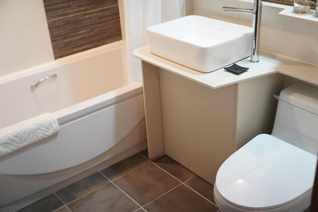 A bathroom with a white bathtub, a white toilet, and a white sink.