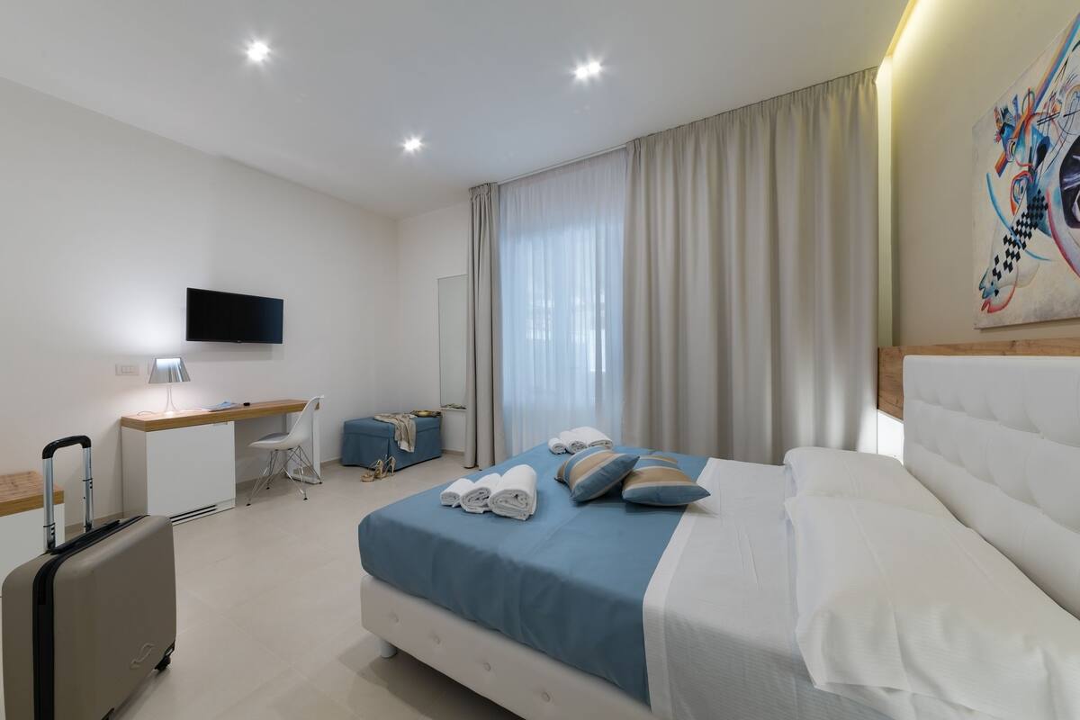 Habitación triple Deluxe, patio | Ropa de cama de alta calidad, edredón y minibar
