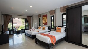 A hotel room with two beds, a desk, and a large window with curtains.