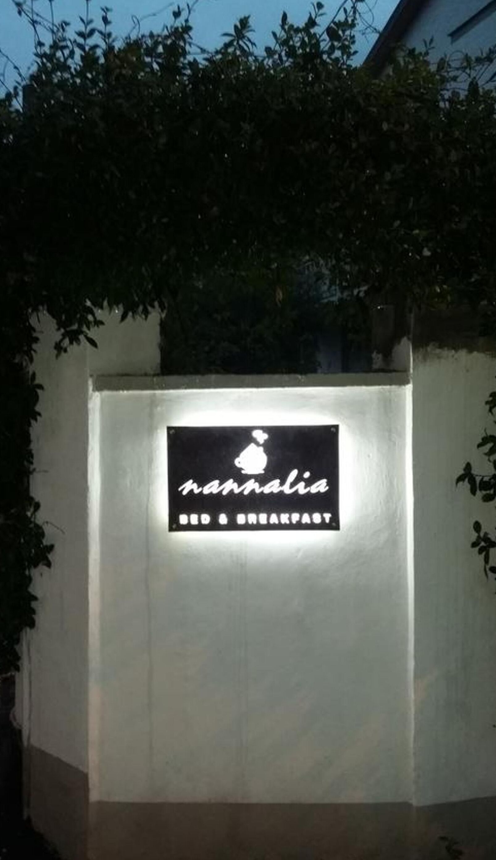 A sign for 'nannalia Bed & Breakfast' with a silhouette of a house and a heart above the name.