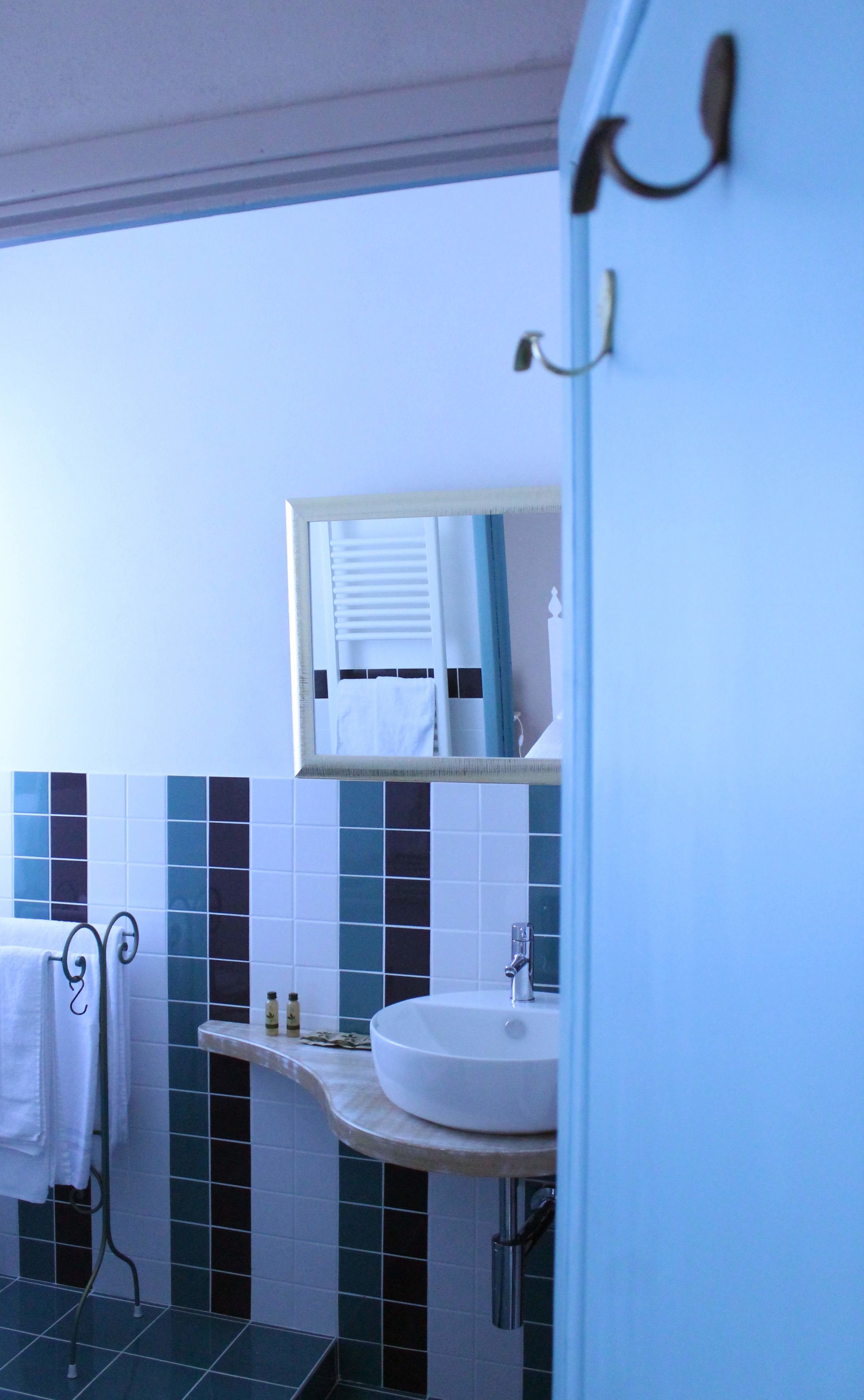 A bathroom with a white sink, a mirror, and a towel rack.