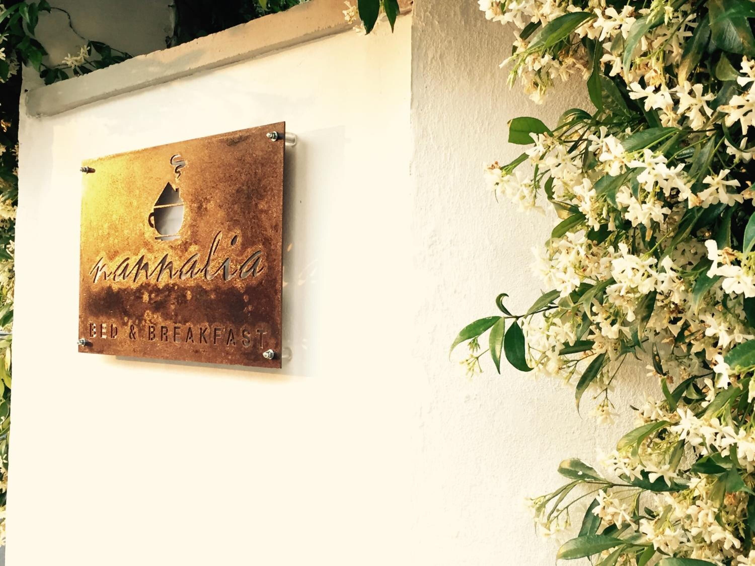 Een bordje met 'Mammalia Bed & Breakfast' bevestigd aan een muur.