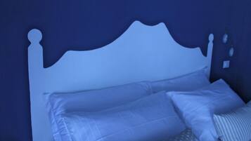 A bed with a white headboard and multiple pillows.