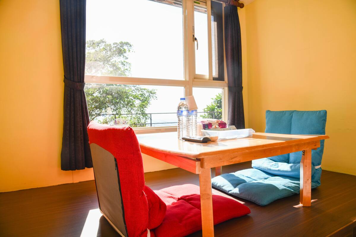 Una habitación con una mesa de madera, una silla roja y un sofá azul.