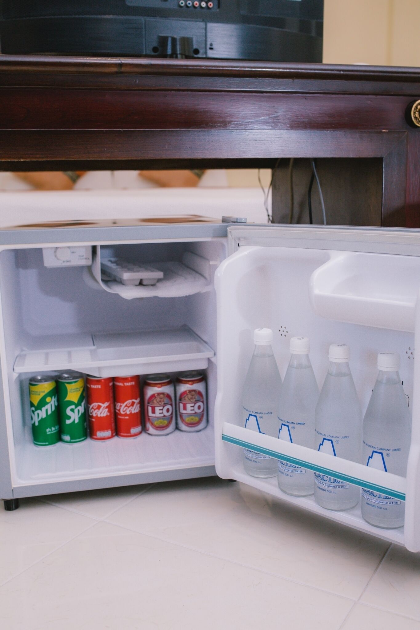 A small refrigerator with beverages and cans.