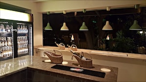 A bar area with a counter, bottles, and baskets. - Eon Dalyan Boutique Hotel (Ortaca)