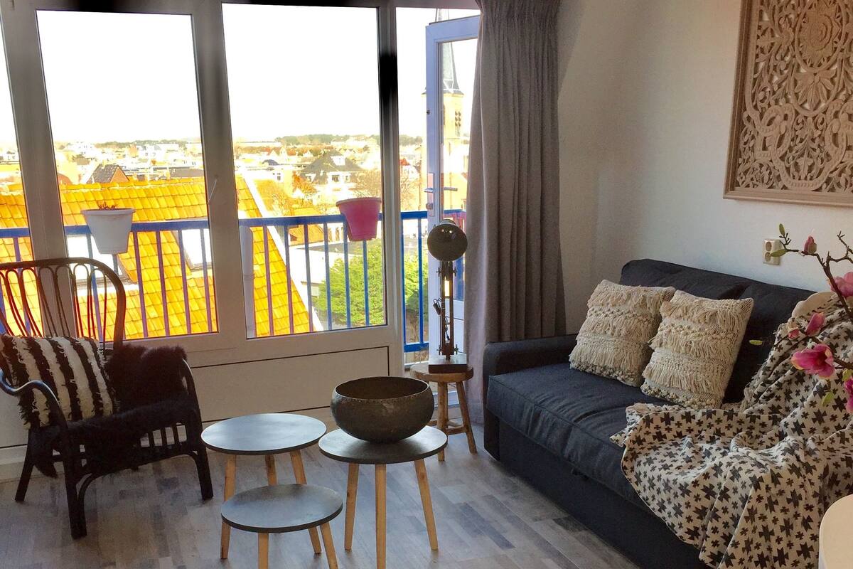 Un salon comprenant un canapé, deux fauteuils, une table basse et un lampadaire.