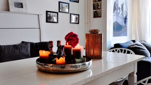 Un coin repas avec une table décorée de bougies et d’un vase ornemental.