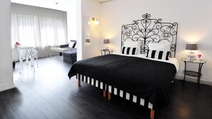 Une chambre d’hôtel moderne, dotée d’un grand lit, d’un bureau et d’une chaise.