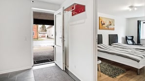 Un dormitorio moderno con una cama, un cuadro y una lámpara roja.