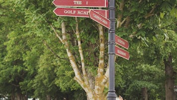 En vägvisare med flera pilar som pekar åt olika håll, mot bland annat utslagsplats 1, golfakademin, puttinggreenen, receptionen och restaurangen.