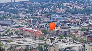 Un paisaje urbano con diversos edificios, incluyendo un edificio destacado de techo rojo en primer plano.