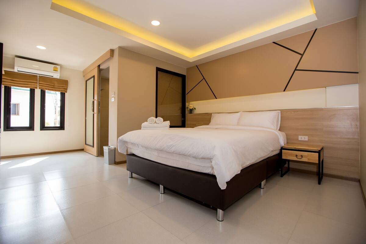Un dormitorio moderno con una cama grande, mesitas de noche y un armario empotrado.