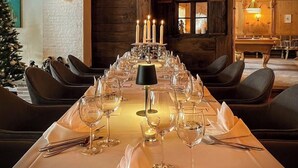 A long dining table set for a meal with candles, glasses, and cutlery. - Villa Stelvio Bed & Breakfast (Val Muestair)