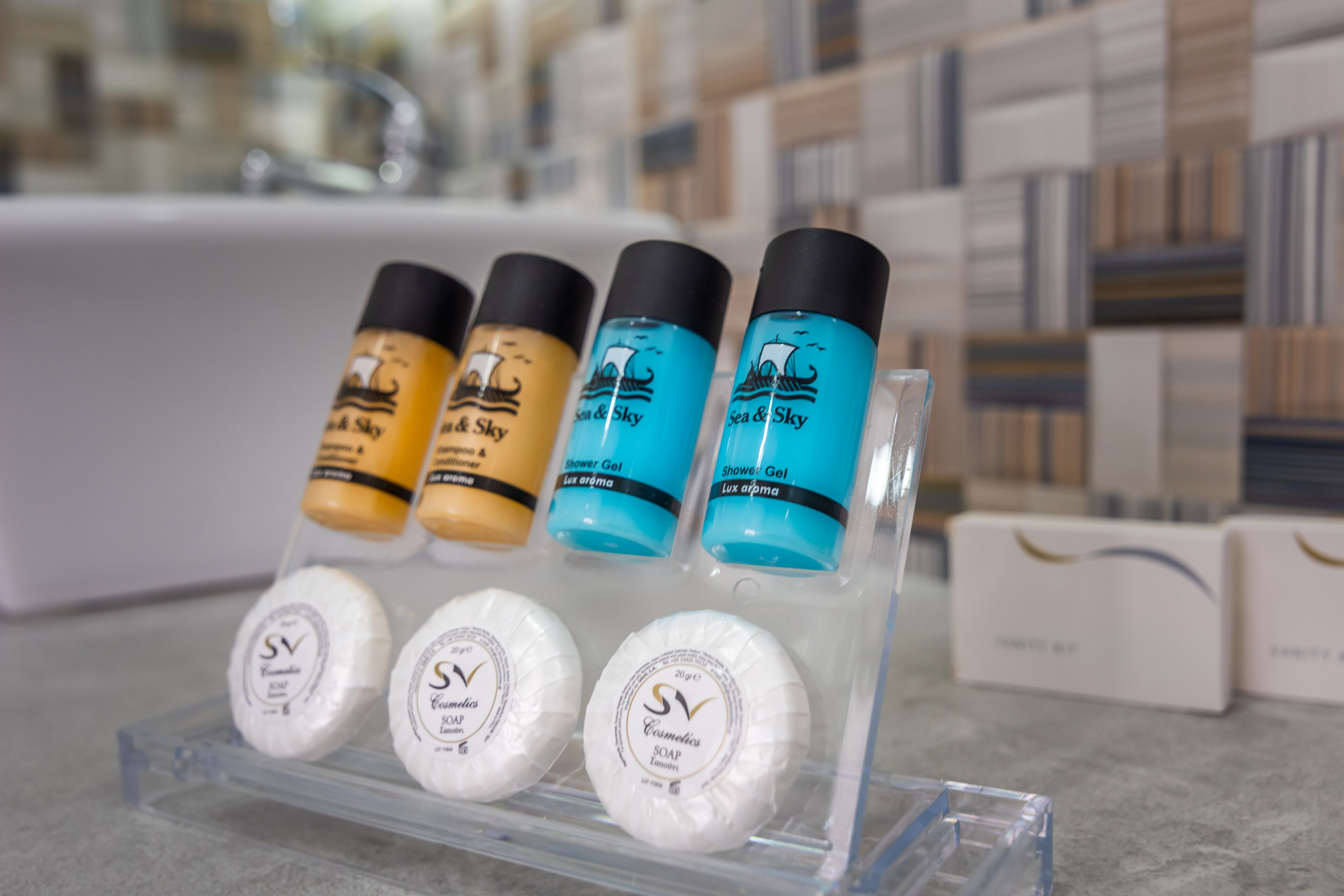 A display of various toiletries including shower gel and soap in a clear plastic holder.