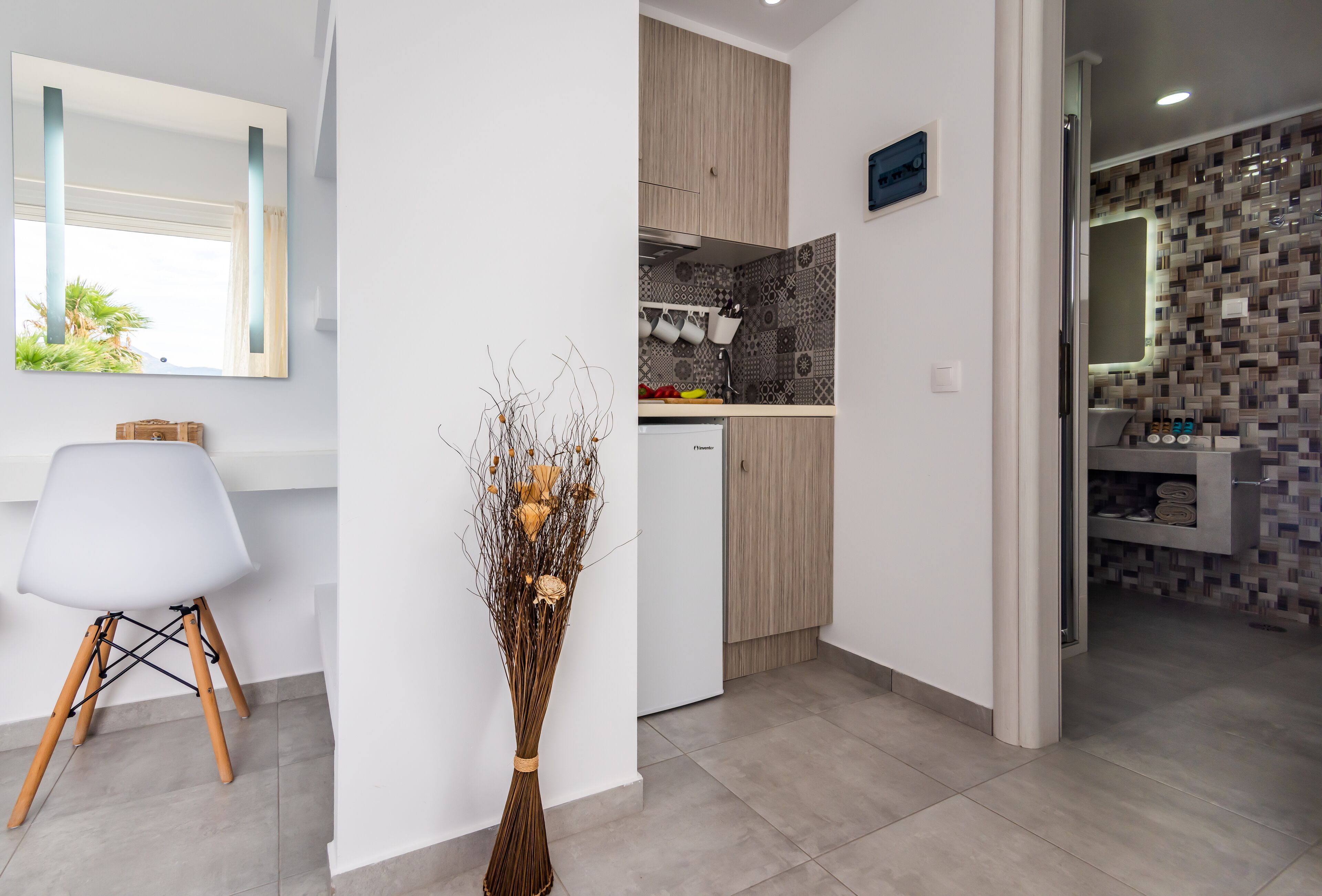 Una cocina moderna con un armario blanco, un refrigerador pequeño y un salpicadero de azulejos.