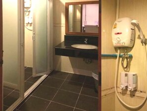 A bathroom with a sink, mirror, and a hairdryer mounted on the wall. - Mojo House (Chiang Mai)